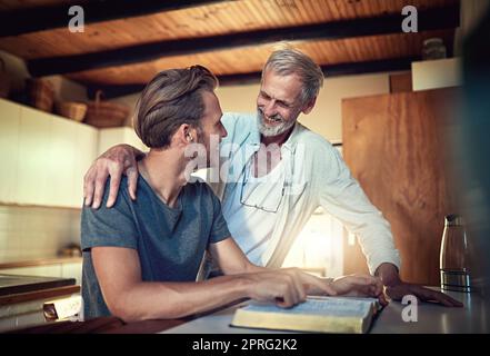 Everyone needs a spiritual mentor. a father and son doing Bible study together at home. Stock Photo