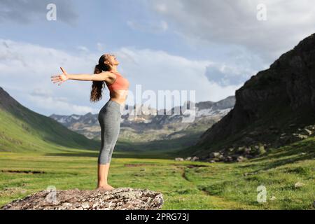 Yogi outstretching arms celebrating in the mountain Stock Photo