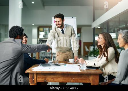 Welcome to the team. two businessmen shaking hands during a meeting. Stock Photo