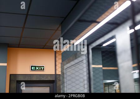 Exit sign in Ukrainian and English hangs above door in public place. Stock Photo