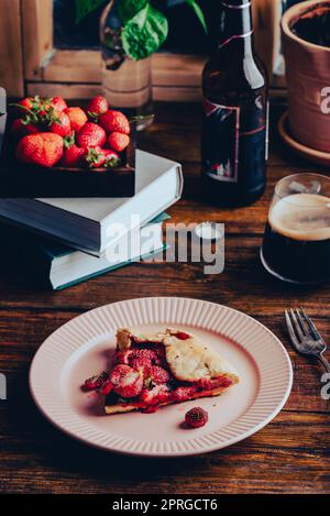 Portion of Strawberry and Sorrel Galette on Plate with Glass of Stout Stock Photo