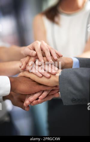 All for one and one for all. a group of unrecognizable businesspeople with their hands in a huddle. Stock Photo