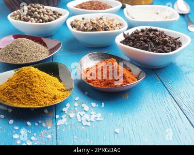 Assortment of organic spices and herbs on a blue wooden table Stock Photo