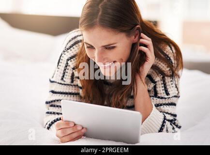 Enjoying her wireless weekend. a beautiful young woman using a digital tablet at home. Stock Photo