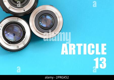 Several photographic lenses and article 13 inscription on blue background. European copyright directive including article 13 is approved by european p Stock Photo