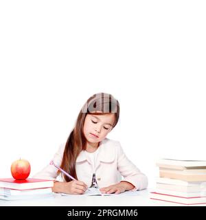 Happy and cute teen school girl writes in a book or notebook Stock Photo