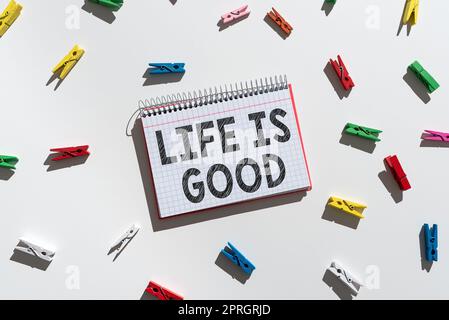Text caption presenting Life Is Good. Internet Concept Obtain everything you want and more have health great job Important Message Written On Notebook With Colorful Paperclips Around. Stock Photo