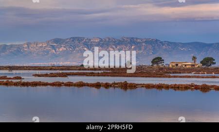 Montsià mountain range seen from near the Barra del Trabucador isthmus with its reflection on the waters of the Alfacs bay in the Ebro Delta (Spain) Stock Photo