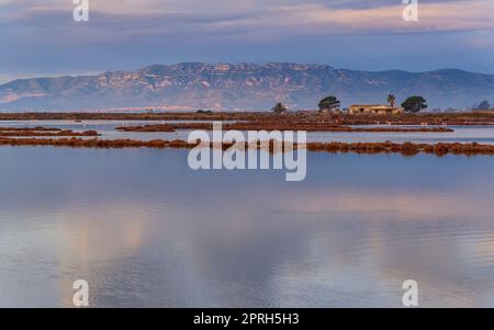 Montsià mountain range seen from near the Barra del Trabucador isthmus with its reflection on the waters of the Alfacs bay in the Ebro Delta (Spain) Stock Photo