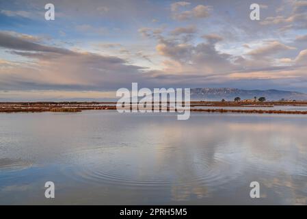 Montsià mountain range seen from near the Barra del Trabucador isthmus with its reflection on the waters of the Alfacs bay in the Ebro Delta (Spain) Stock Photo