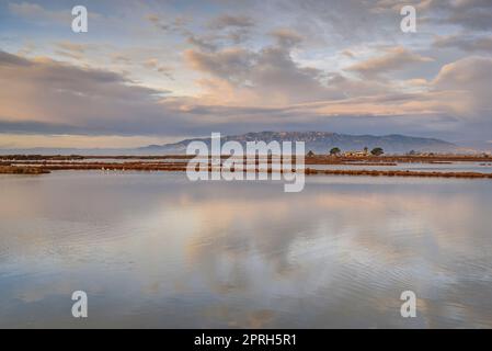 Montsià mountain range seen from near the Barra del Trabucador isthmus with its reflection on the waters of the Alfacs bay in the Ebro Delta (Spain) Stock Photo