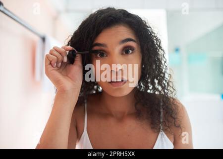 Making her eyes pop. Portrait of an attractive young woman applying mascara in the bathroom. Stock Photo