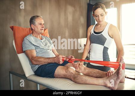 Helping patients with spine and joint problems is my job. a senior man being treated by a physiotherapist. Stock Photo