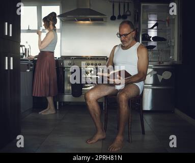Marriage, problem and mental health issue with bored old couple in toxic, dark or sad family home kitchen together. Divorce, alcoholic and depression married relationship with broken household Stock Photo