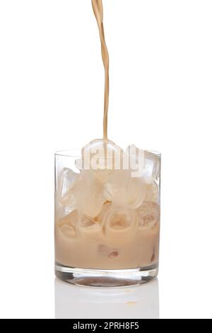 Irish creme liqueur pouring in a glass full of ice. Stock Photo