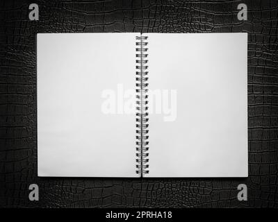 blank spiral notebook on a black leather background Stock Photo