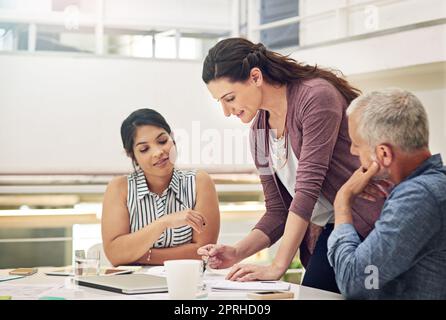 Shes fully prepared for their team meeting. a team of colleagues having a meeting in a modern office. Stock Photo