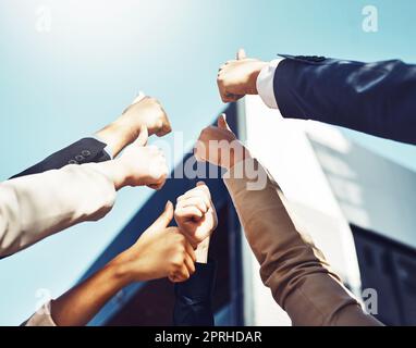 We believe in doing things together. a group of businesspeople showing a thumbs up gesture. Stock Photo