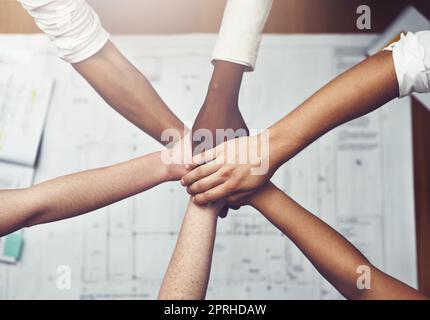 We all work together in perfect harmony. unrecognizable businesspeople joining their hands together in unity. Stock Photo