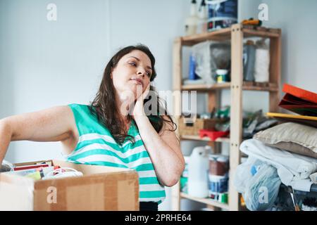 Shes tired of all the chores. a young woman overwhelmed from doing chores. Stock Photo