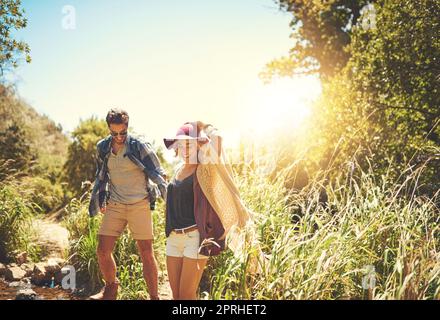 Their favorite place to spend time together is in nature. a happy young couple exploring nature together. Stock Photo