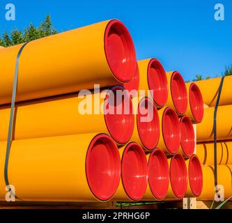 Stack of orange pvc protective pipes Stock Photo