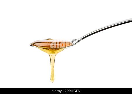 Honey dripping from spoon, isolated on white. Stock Photo