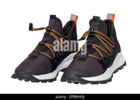 Closeup of a pair of modern black sneakers or sports shoes isolated on a white background. Clipping path. Elegant and trendy mans shoes. Macro. Stock Photo