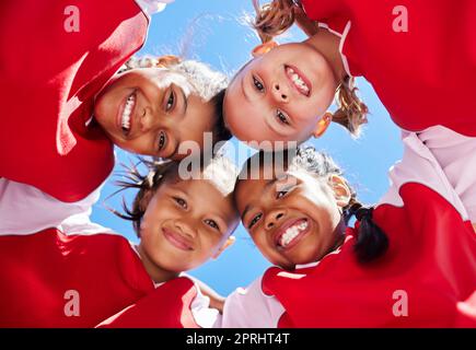 Huddle, motivation and girl team in soccer planning a fitness strategy with teamwork on sports football field. Low angle, brazil and happy friends hav Stock Photo
