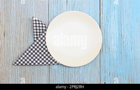 white plate on tablecloth on wood table background Stock Photo