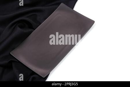 Empty black rectangle modern ceramic plate with silk tablecloth texture on white background , Top view Stock Photo