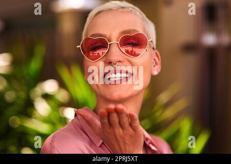 Im all about spreading love and positivity. Portrait of an attractive young woman blowing kisses outdoors Stock Photo