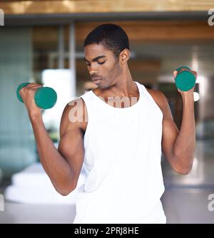 https://l450v.alamy.com/450v/2prj8he/this-is-his-time-to-tone-a-fitness-shot-of-a-young-man-toning-with-weights-2prj8he.jpg