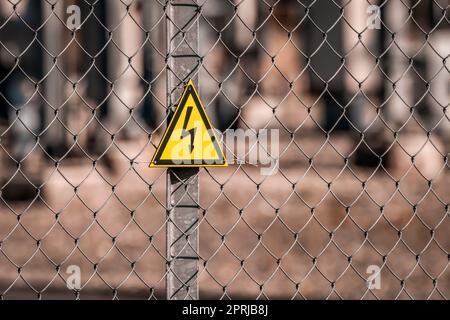 Electrical hazard sign placed on a fence of an electrical substation Stock Photo