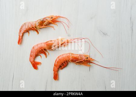 Top view of unpeeled shrimp with head on wooden table Stock Photo