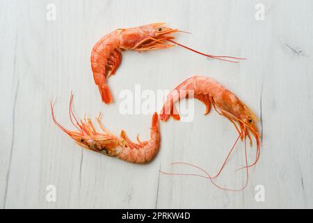 Top view of unpeeled shrimp with head on wooden table Stock Photo