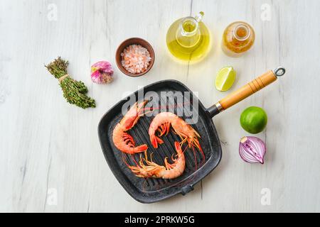 Top view of unpeeled shrimp with head in cast iron skillet Stock Photo