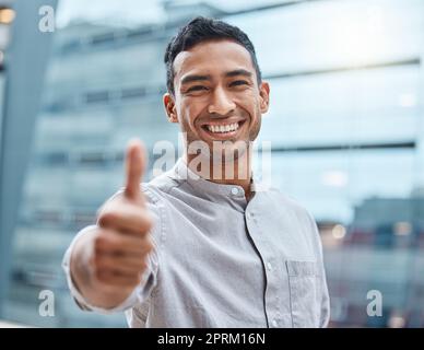 Thats why youre awesome. a young businessman showing thumbs up against an urban background Stock Photo