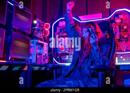 Young woman wear gaming headphones playing esports games console gaming room, Gamer using joystick controller for virtual tournament plays online vide Stock Photo