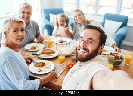 Love, selfie and food with big family in home for cheerful photograph together in Australia. Parents, grandparents and child at lunch dining table wit Stock Photo