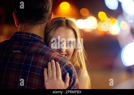 I love being in his arms. a young couple out on a date in the city. Stock Photo