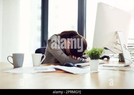 Shes reached the point of burn out. an exhausted young businesswoman lying with her head on her desk. Stock Photo