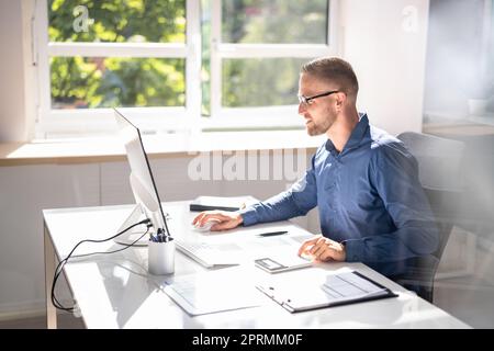 Accountant Using E Invoice Software At Computer Stock Photo