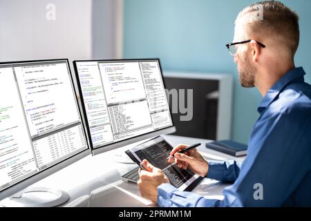 Computer Programmer Writing Program Code On Computer Stock Photo