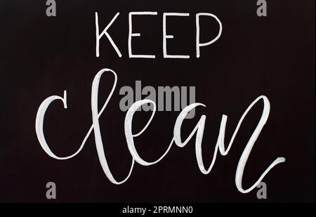 Chalk inscription KEEP CLEAN on a black chalkboard Stock Photo