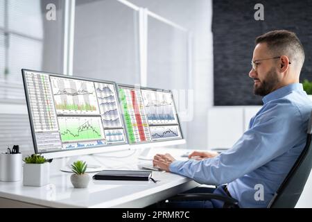 Stock Market Analyst At Office Desk Stock Photo