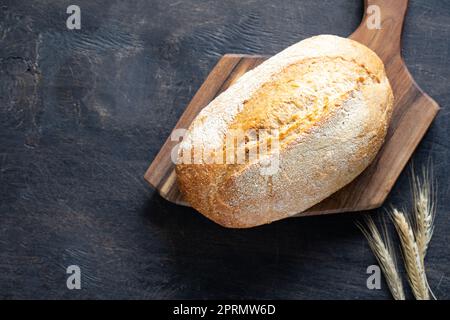 freshly baked bread on wooden cutting board Stock Photo