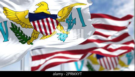 Flags of United States Virgin Islands waving in the wind with the US flag on a clear day Stock Photo