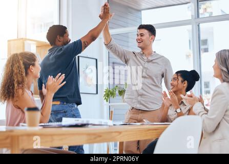 Business people giving high five for success in meeting, people clapping hands for team achievement and in celebration of company win. Excited, growth and support in partnership at work office Stock Photo