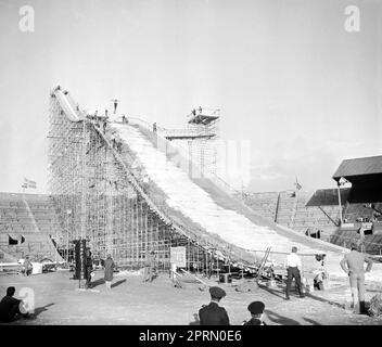 File photo dated 31-05-1961 of A mesh of scaffolding takes the place of the customary mountain slope as a skier soars through the air on the way down to an arena that's seen rodeos, cup finals and other spectacles but has not, until now, staged a ski jumping contest. Wembley was the unlikely venue for a Winter Sports Exhibition in the summer of 1961, with a mesh of scaffolding replacing the customary mountain for a ski jump. Issue date: Thursday April 27, 2023. Stock Photo